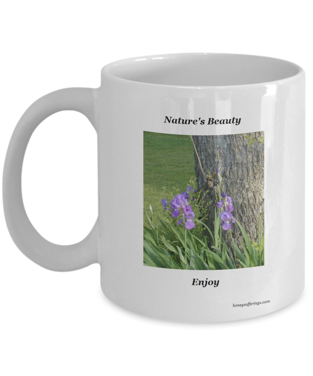 Purple Iris Flower Coffee Mug with picture of purple irises displaying their beauty at the base of a tree. A mug for those who love the purple iris flower.  Enjoy your morning espresso while viewing this beautiful purple colored iris image on the side of your cup. Purple Iris Mug Gift for the Flower Lover.